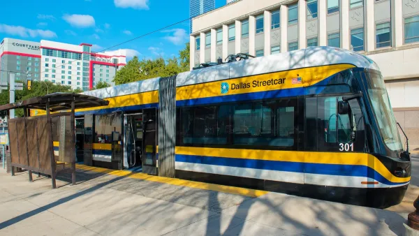 White, yellow, and blue Dallas Streetcar at station in downtown Dallas, Texas.