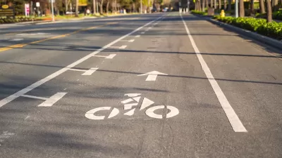 Bike lane marked with white paint on asphalt street.