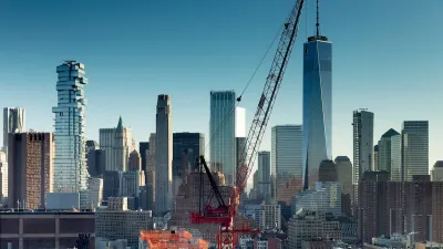 Red crane in foreground with New York City skyline in background.