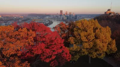 View of downtown Pittsburgh, PA with colorful fall trees in foreground.