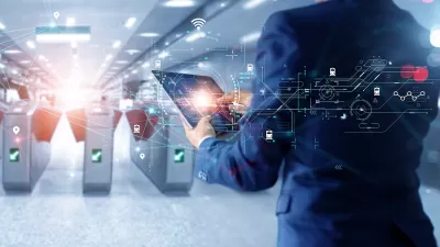 Man in suit holding tablet looking at subway turnstiles with superimposed graphics signaling technology and AI.