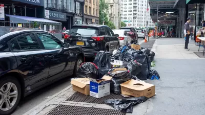 Parked cars and bags of trash on New York City sidewalk.