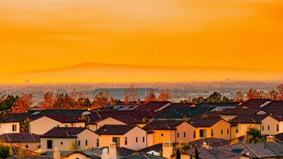 View of Spanish-style homes in dense neighborhood in Orange County, California at sunset.
