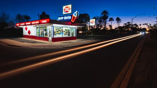 Historic Dairy Queen restaurant building with neon signs at night.