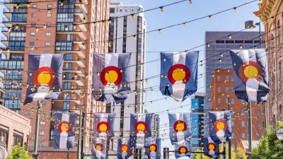 Colorado flags draped between buildings in downtown Denver, Colorado.