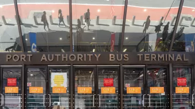 Entrance to Port Authority Bus Terminal with glass doors and sign in midtown Manhattan, New York City.