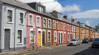 Cars parked along a narrow street with colorful two-story houses in Dublin, Ireland.