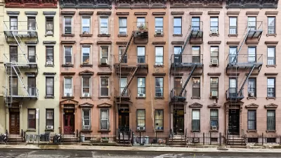Row of 4-story brick New York City apartment buildings.