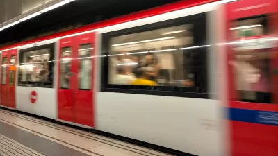 Red and white Barcelona Metro train passing through station.