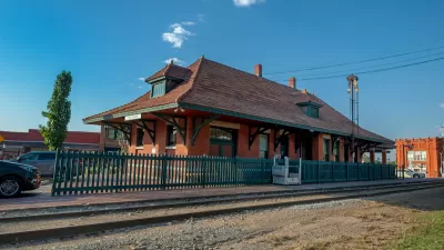 Small brick building with green roof housing old train station and visitor center in Van Buren, Arkansas