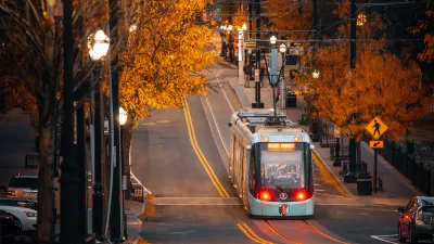 Kansas City streetcar running down street lined with trees in fall colors.