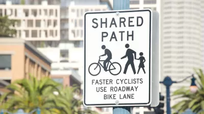Close-up of "Shared Use Path" sign for pedestrians and cyclists on post in urban setting.