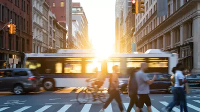 People, cars, bikes and buses traveling through a busy intersection on 5th Avenue and 23rd Street in New York City with shining sunlight background.