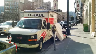 U-Haul moving van parked by a curb in San Francisco with mattress leaning against it