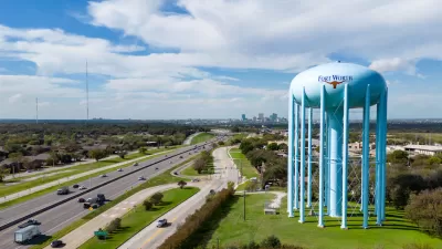 Aerial view of freeway and large blue water tower with Fort Worth logo on it in Fort Worth, Texas.