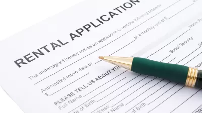 Close-up of rental application laying on table with green pen laying across the paper