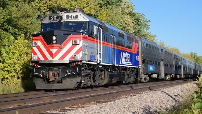 Chicago Metra heavy rail commuter train on track with trees in background.
