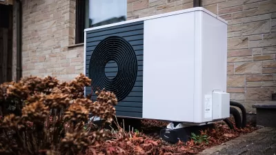 White geothermal heat pump installed on the side of a house