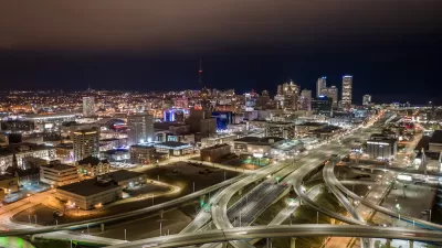 Aerial view of Milwaukee, Wisconsin skyline with freeway interchanges in foreground at night.