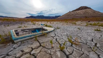Small boat stranded on cracked dry earth in Lake Mead area during a drought.