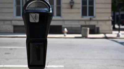 Close-up of black parking meter with blurred street in background