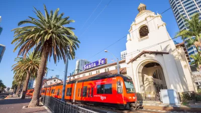 Red San Diego trolley in front of 1915 Neo-Spanish building at Santa Fe Depot in downtown San Diego, California.