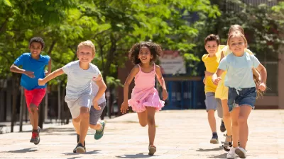 Group of children running outdoors toward camera.