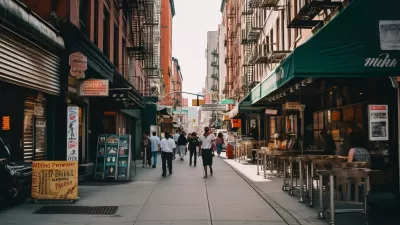 View of New York City alleyway with outdoor restaurant seating and people walking between brick apartment buildings with fire escapes