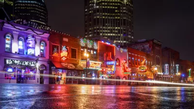 View from street level of brightly neon-lit bars and theaters on Broadway in downtown Nashville, Tennessee.
