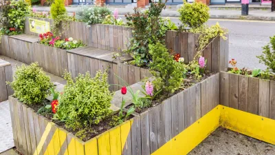 Parklet with wooden benches and flower boxes on street in Ireland.