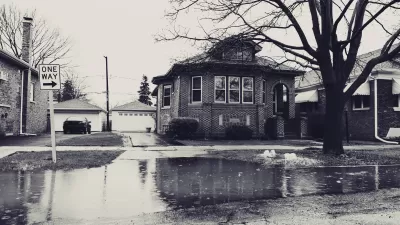 Sepia-toned photo of flooded street with residential home