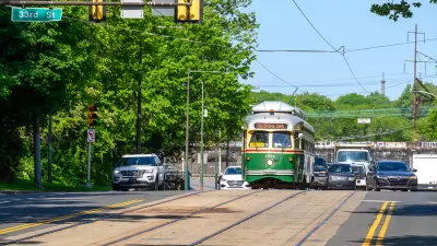 Vintage green Phialdelphia trolley moving down street