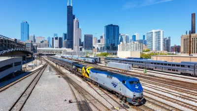 Amtrak train at Union Station with Chicago skyline in background.