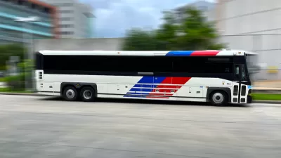 Houston Metro bus moving rapidly across blurred background.