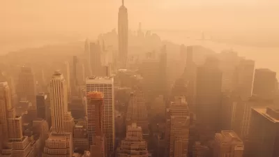 Aerial view of New York City including Empire State Building blanketed in orange wildfire smoke