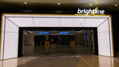 Empty, darkened corridor in transit station before opening with Brightline logo in lights on one side