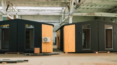 Two black modular units with glass doors and wood accents in an industrial warehouse.