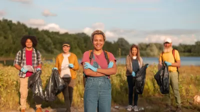 Group of five people standing in a wetland park smiling at the camera during a cleanup event.