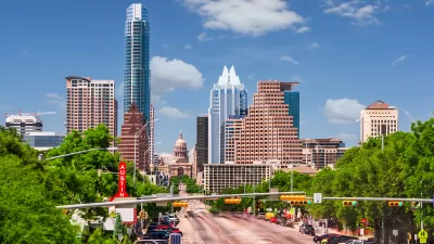 View of Congress Avenue with Texas state capitol dome among high-rise buildings in downtown Austin, Texas.