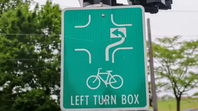 Close-up of green sign for bike box for turning in intersection.