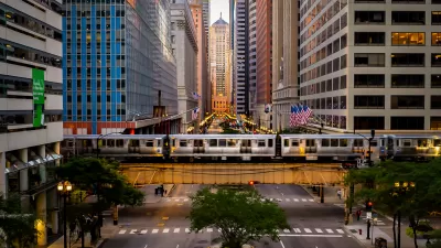 A view straight down LaSalle Street, lined by high-rise buildings with an El line running horizontally over the street.