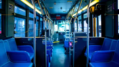Empty interior of New York City bus with blue seating.