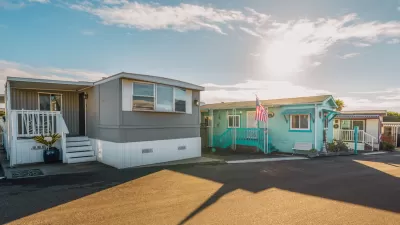 Row of colorful mobile homes on an asphalt street.