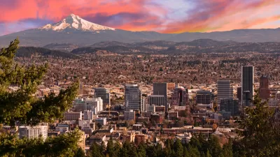 Sweeping view of Portland, Oregon with Mt. Hood in background against sunset sky.