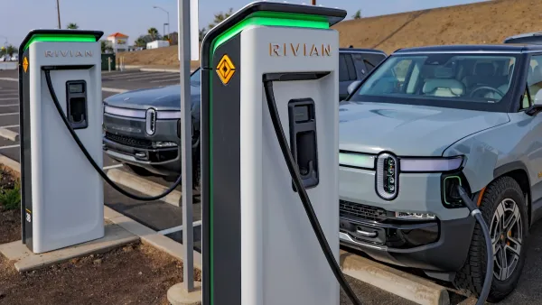 Two Rivian trucks charging at Rivian branded charging ports.