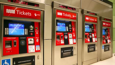 Row of four red and white MUNI ticketing machines in transit station in San Francisco, California.