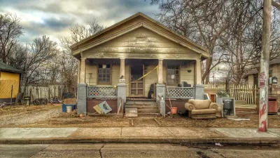 Old single-story home with porch in run-down condition