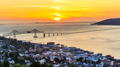 Aerial view of coastal town of Astoria, Oregon with suspension bridge and sunset sky.