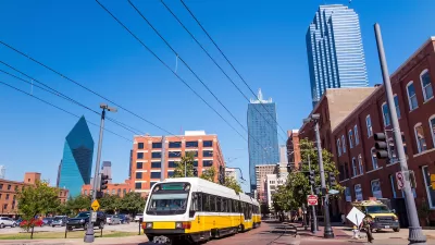 White Dallas light rail car with Dallas skyline in background