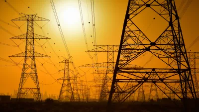 Large power towers sillhouetted against an orange sky